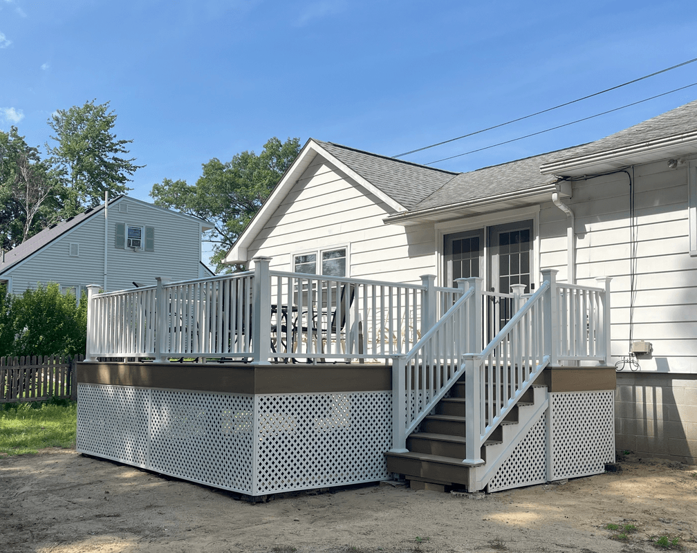 White residential deck with lattice skirting and stairs attached to house