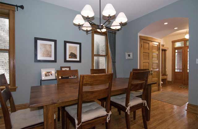 Formal dining room with wooden table, chairs, blue walls, and chandelier
